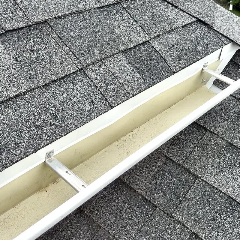 A clean white gutter on a shingled roof