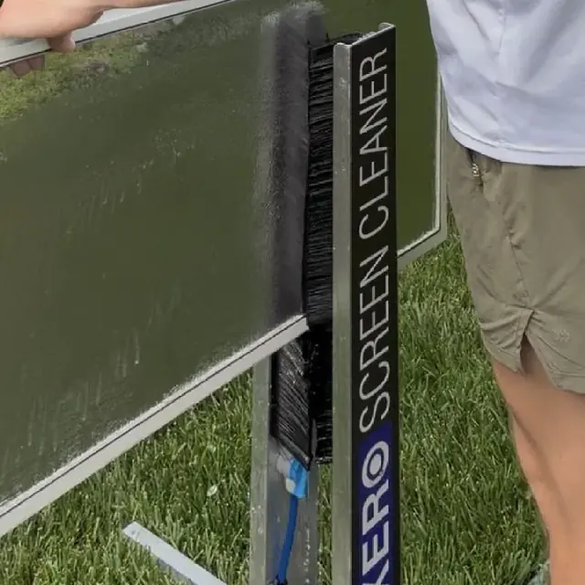 A window screen being cleaned with bristle brushes and water jets